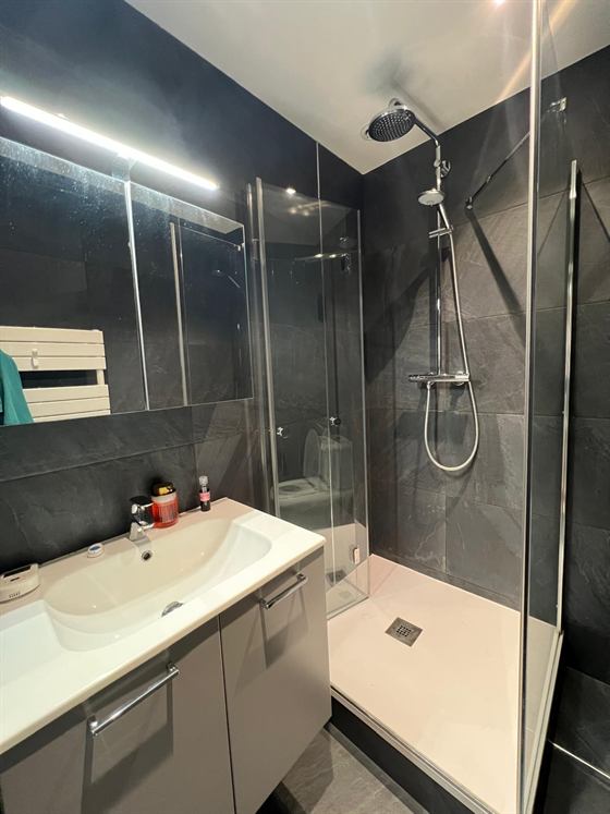 Salle d'eau carrelée avec douche à l'italienne et vasque